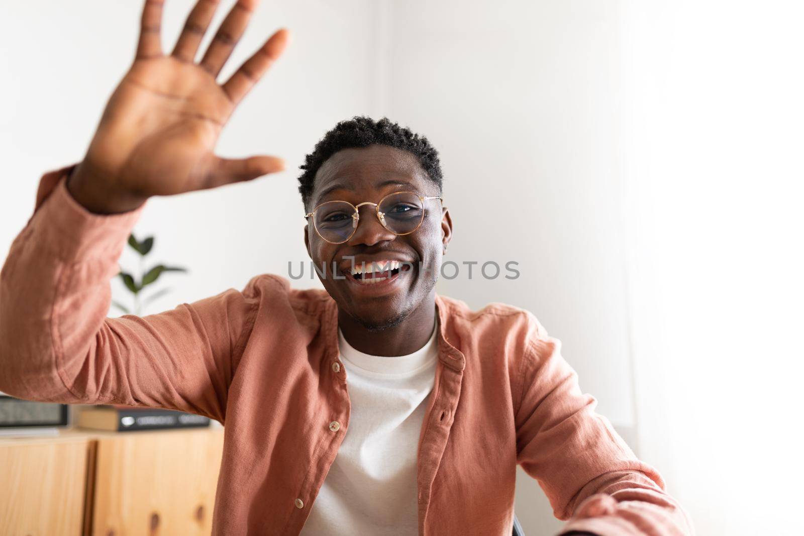 African american young man looking at camera waving hand saying hello during video call. Technology concept.