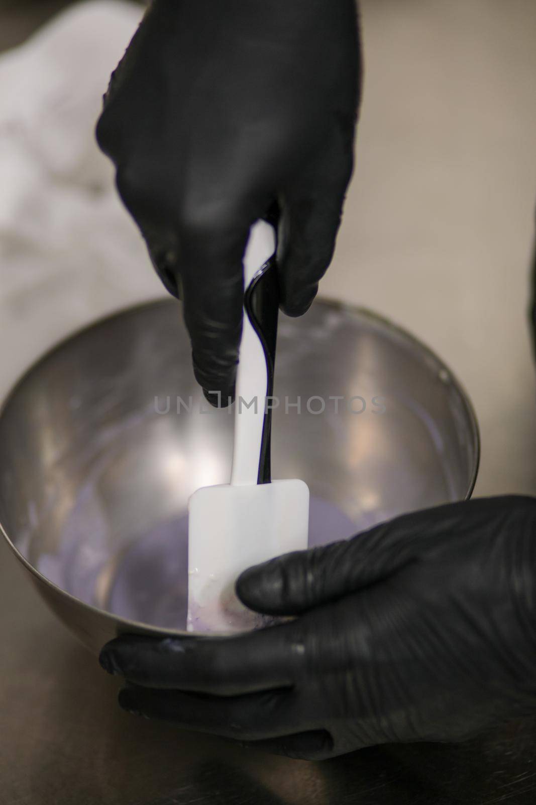 chef making for icing a lilac drip cake in the professional kitchen lab