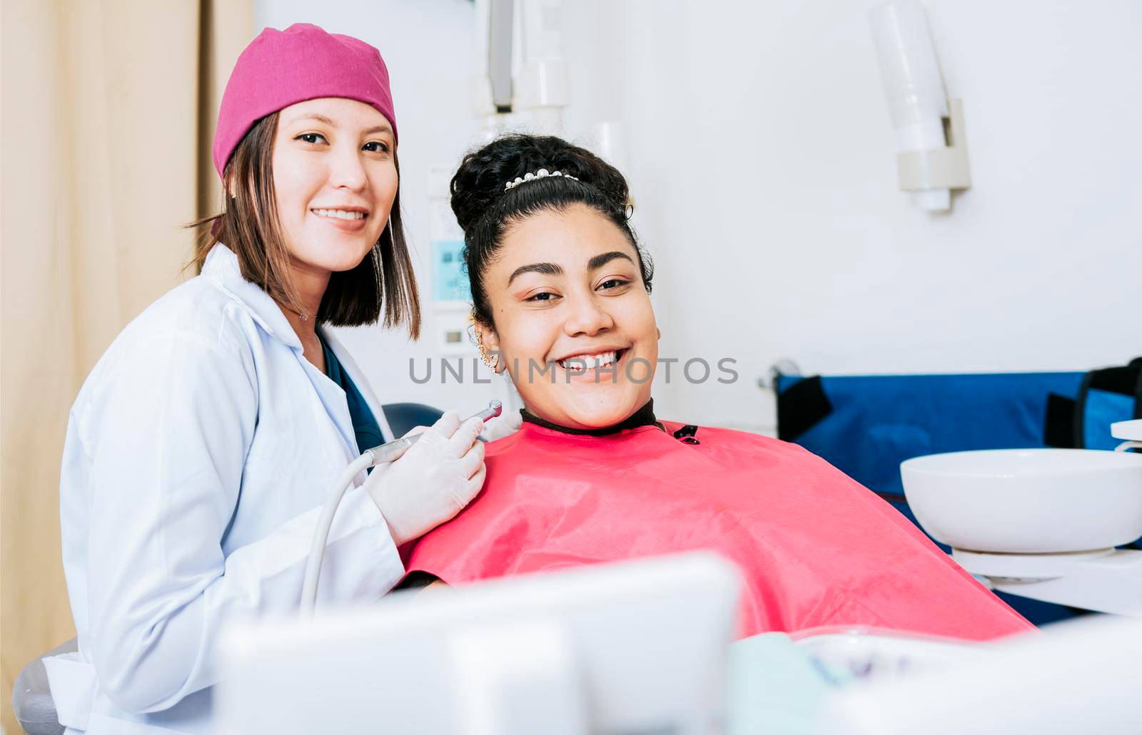 Portrait of smiling dentist with female patient in medical office, Female dentist with smiling female patient looking at camera, Professional dentist with female patient in office