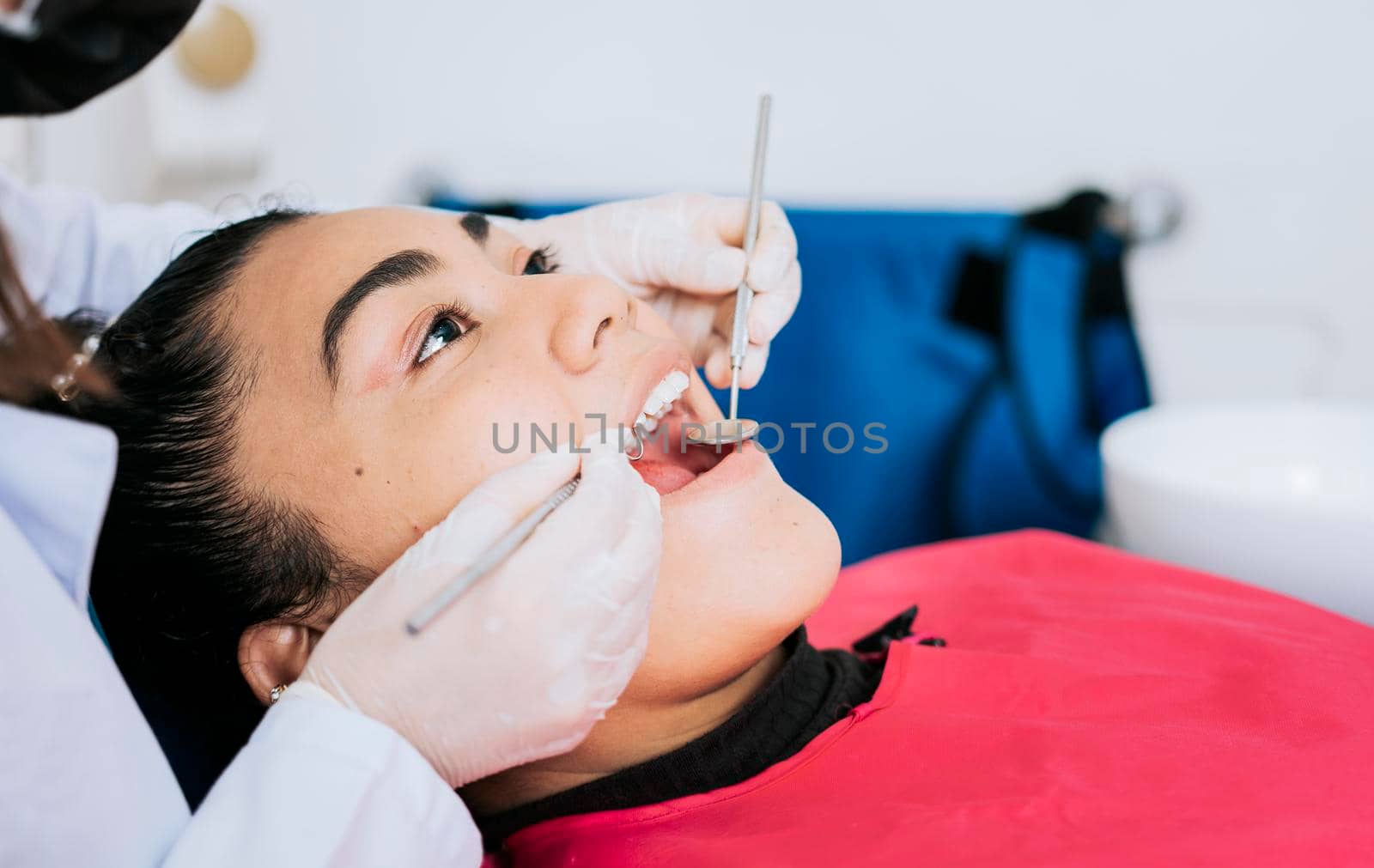 Close up of a dental specialist cleaning a patient's teeth. Close up of professional dentist cleaning female patient teeth, Side view of dentist cleaning female patient teeth with copy space