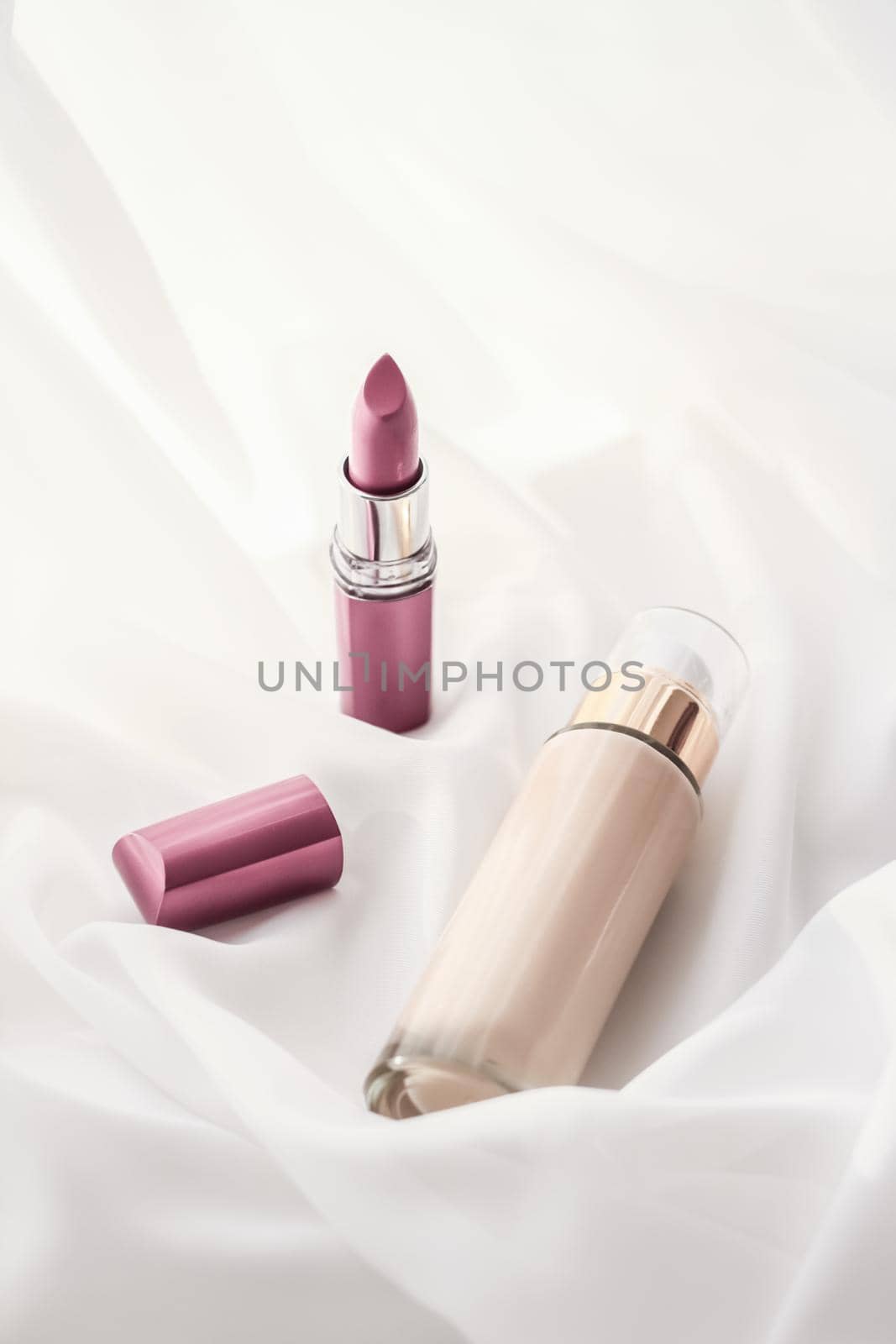 Cosmetic branding, glamour and skincare concept - Beige tonal cream bottle make-up fluid foundation base and pink lipstick on silk background, cosmetics products as luxury beauty brand holiday design