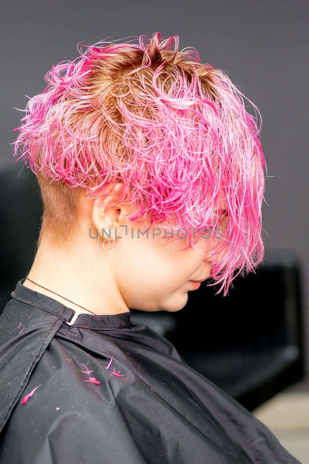 Beautiful young pink haired caucasian woman in the modern hair salon