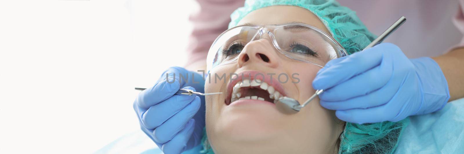 Portrait of woman in dentist chair, appointment at dentist doctor, checkup teeth. Dentist treat teeth with dental instruments. Medicine, teeth care concept