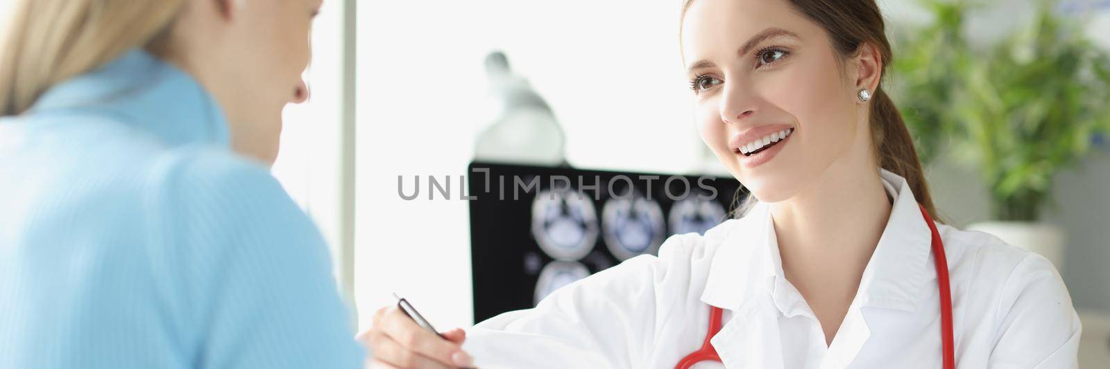 Portrait of woman doctor explain x ray ultrasound result to lady patient. Planned appointment in luxury clinic center. Gynecology, medicine, health concept