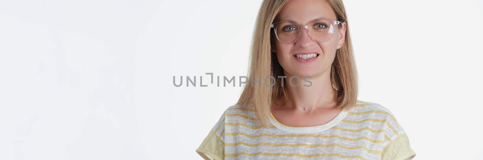 Portrait of blonde beautiful young woman smile on camera posing on white background. Attractive model in shirt in photo studio. Modeling, beauty concept