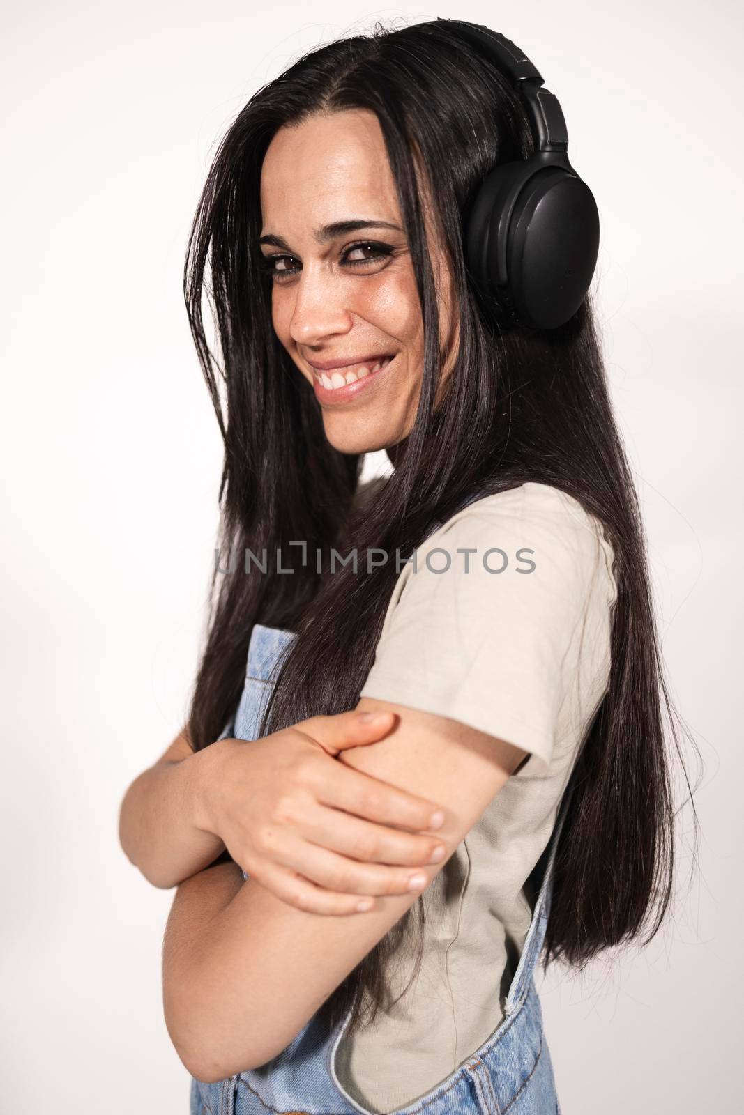 A young casual dressed female musician looking at camera listening to some music by stockrojoverdeyazul