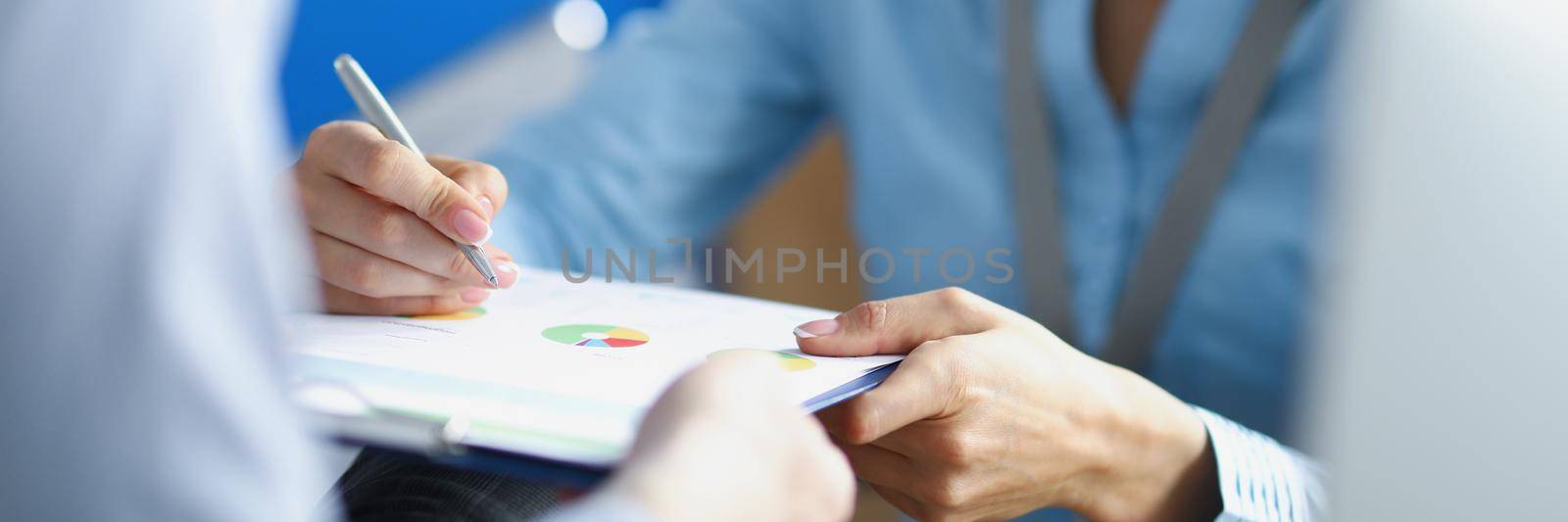Close-up of female worker make correction on business paper with pen. Lady in suit express idea to colleague. Business, plan, creative, strategy concept