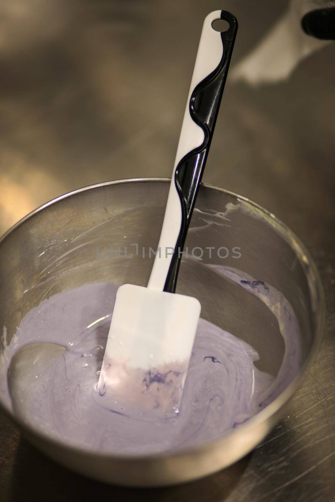 chef making for icing a lilac drip cake in the professional kitchen lab