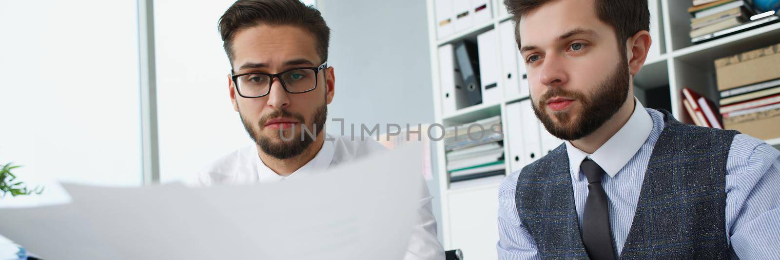 Portrait of group of people hold financial papers, solve and discuss problem. Male team in office, work on creative project. Chaos, mess, business concept