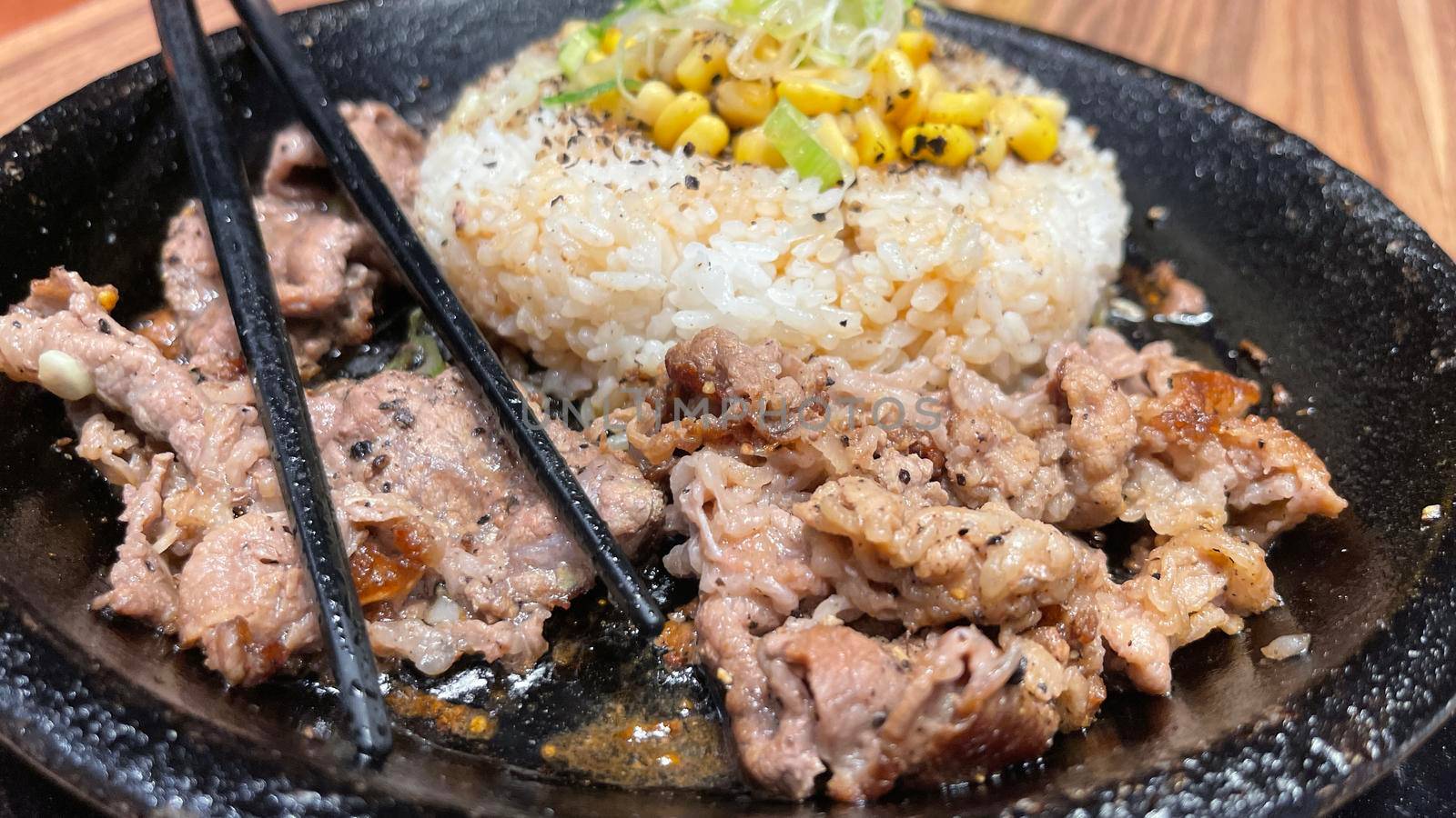 selective focus grilled beef steak with korean sauce bulgogi on top of rice with slice of pepper and sweet corn - korean and japanese food style in a restaurant