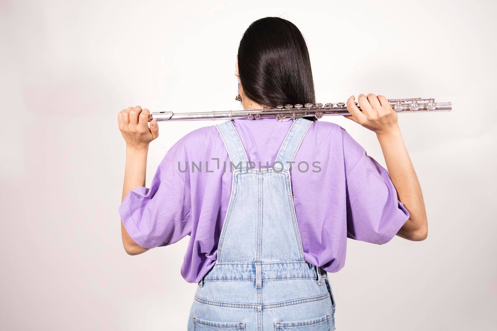 Back view of a young female flutist holding her instrument over her shoulders