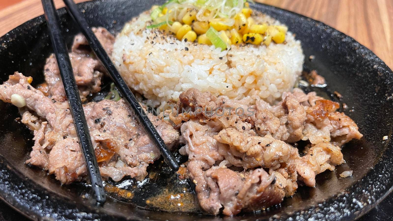 selective focus grilled beef steak with korean sauce bulgogi on top of rice with slice of pepper and sweet corn - korean and japanese food style in a restaurant