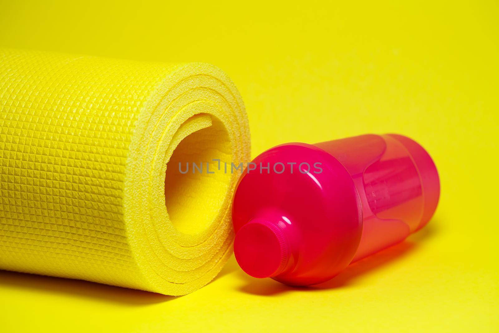 Shaker sport healthy lifestyle sports mat pink water bottle yellow background vibrant paint