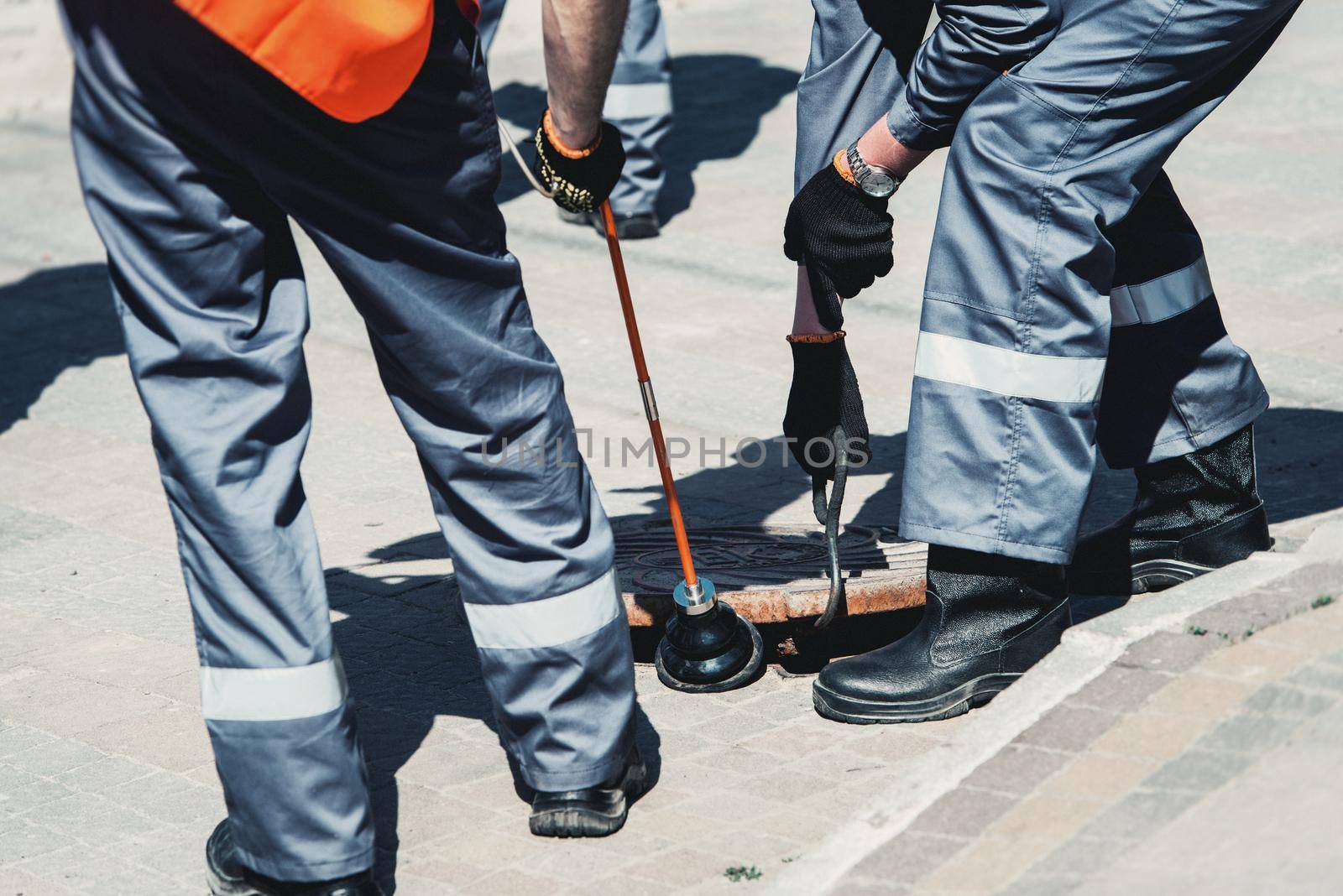 Two workers of emergency gas service, checking concentration of gas in the sewer. looking for a gas leak on the gas pipeline