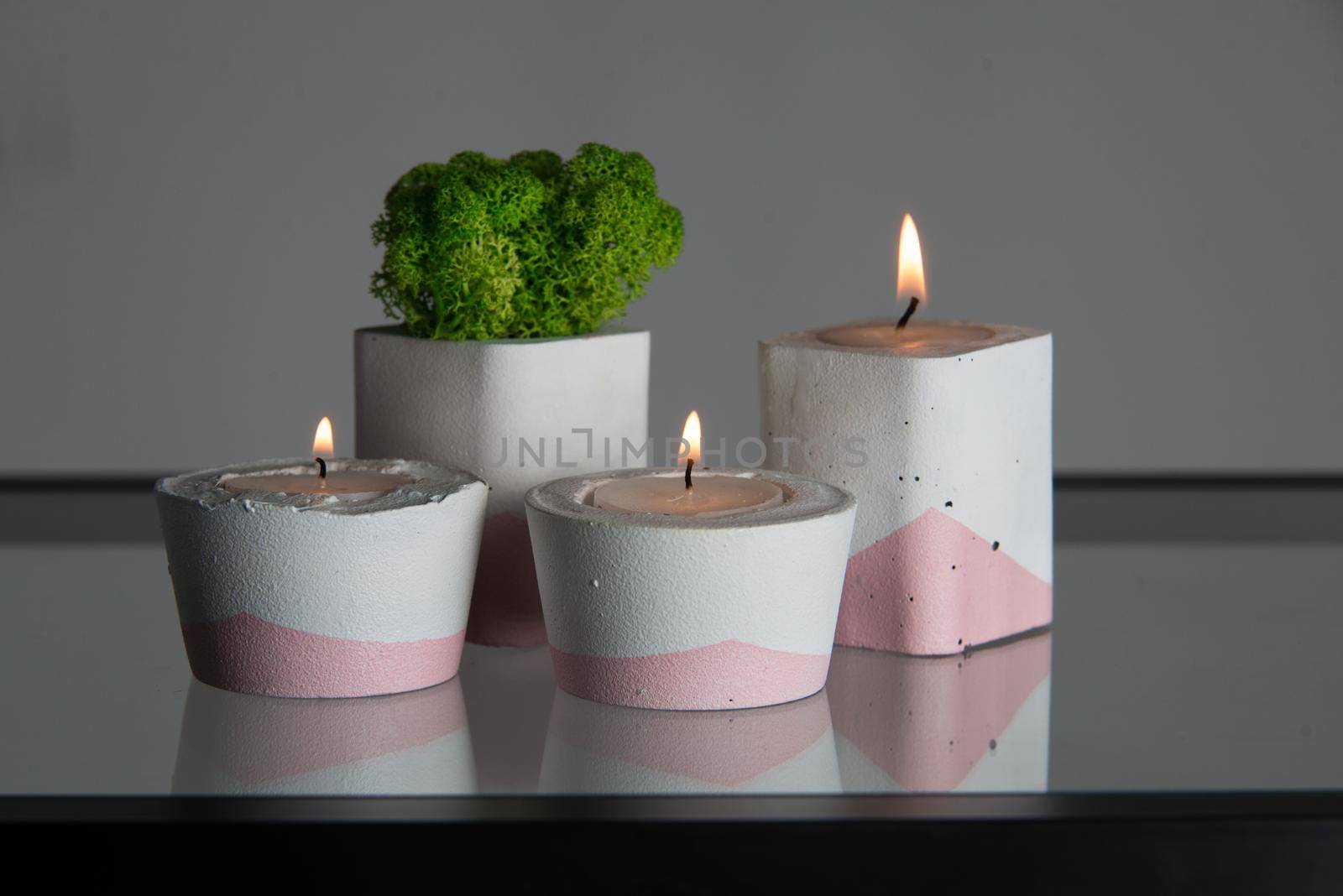 candles and moss in white and pink concrete candle holders.