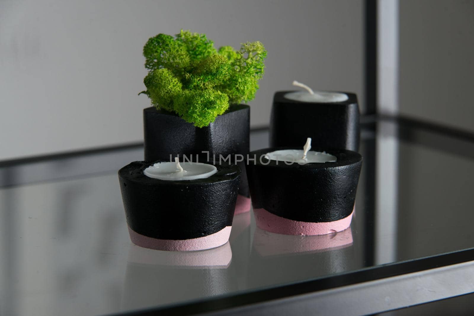 candles and moss in black and pink concrete candle holders.