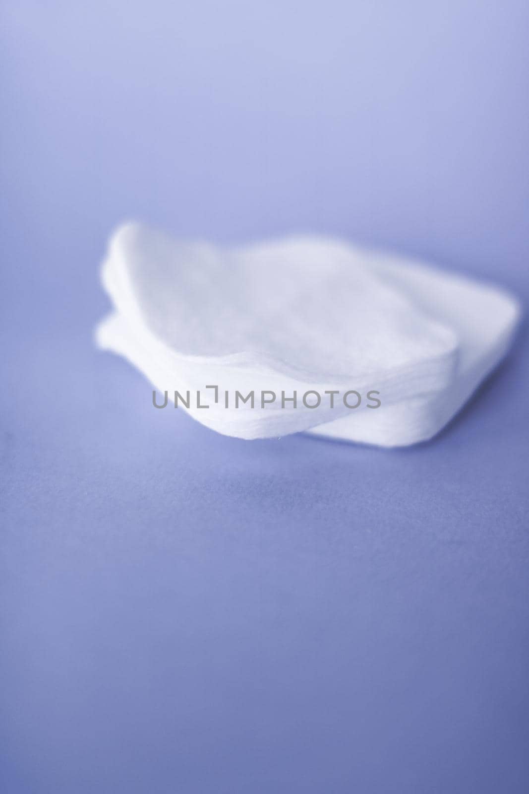 Cosmetology, cleanliness and branding concept - Organic cotton pads on purple background, cosmetics and make-up remover, hygiene and skincare beauty brand product for healthcare and medical design