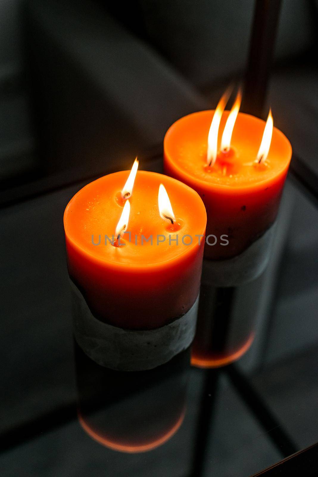 red candle on a gray concrete base.