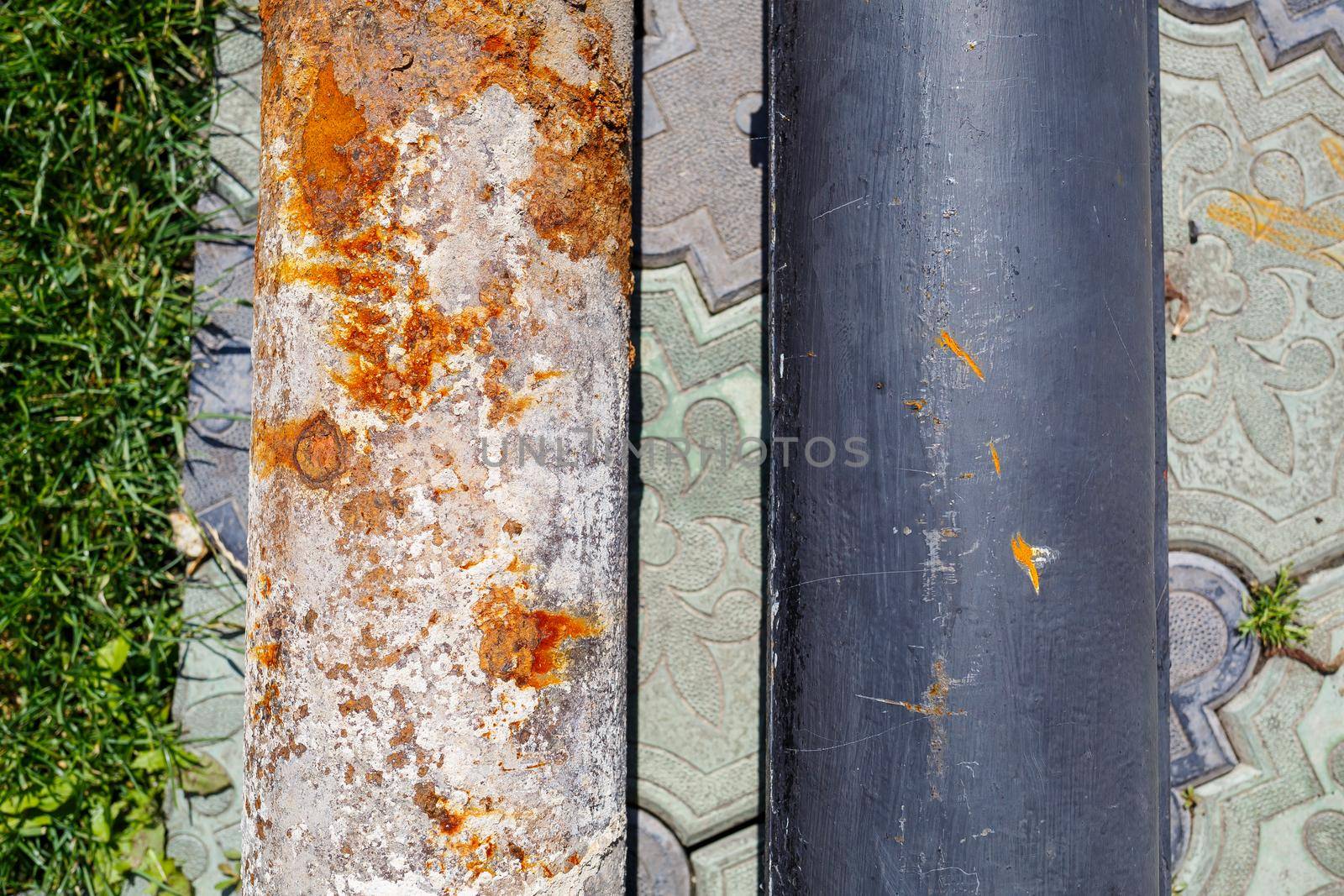 a large metal rusty pipe lies on concrete