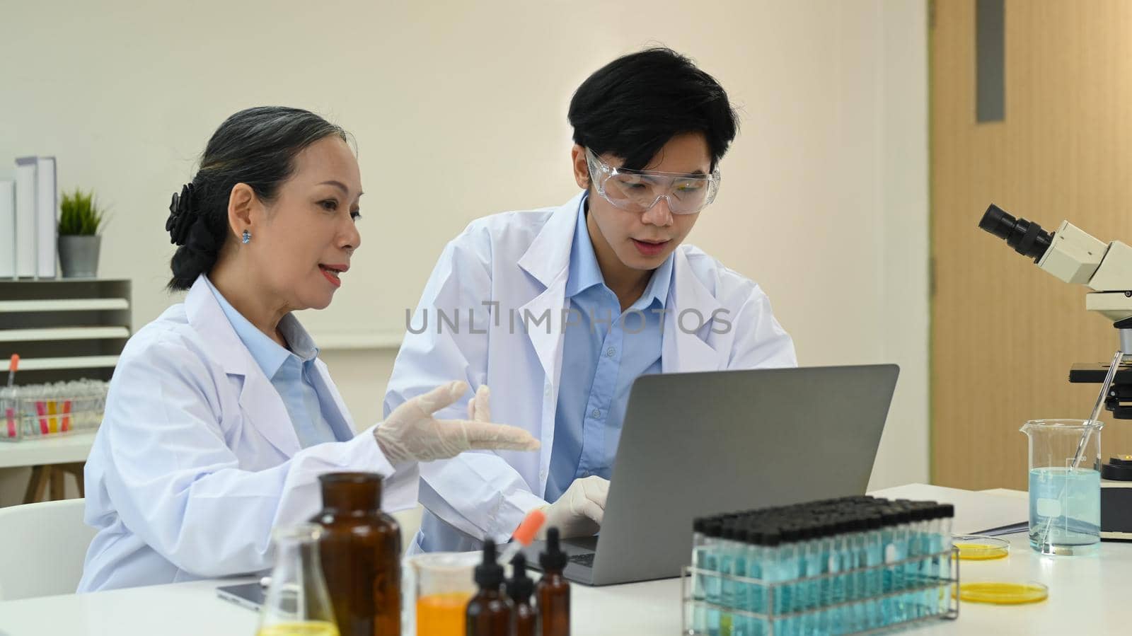 Professional scientists are analyzing test samples, discussing about new test results in science laboratory by prathanchorruangsak