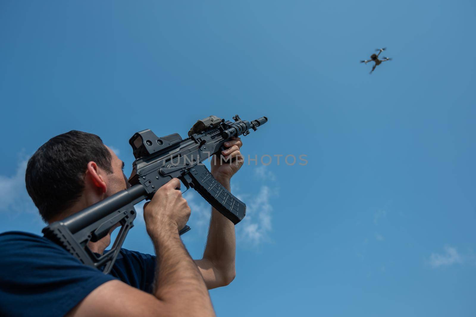 Caucasian man shoots a flying drone with a rifle