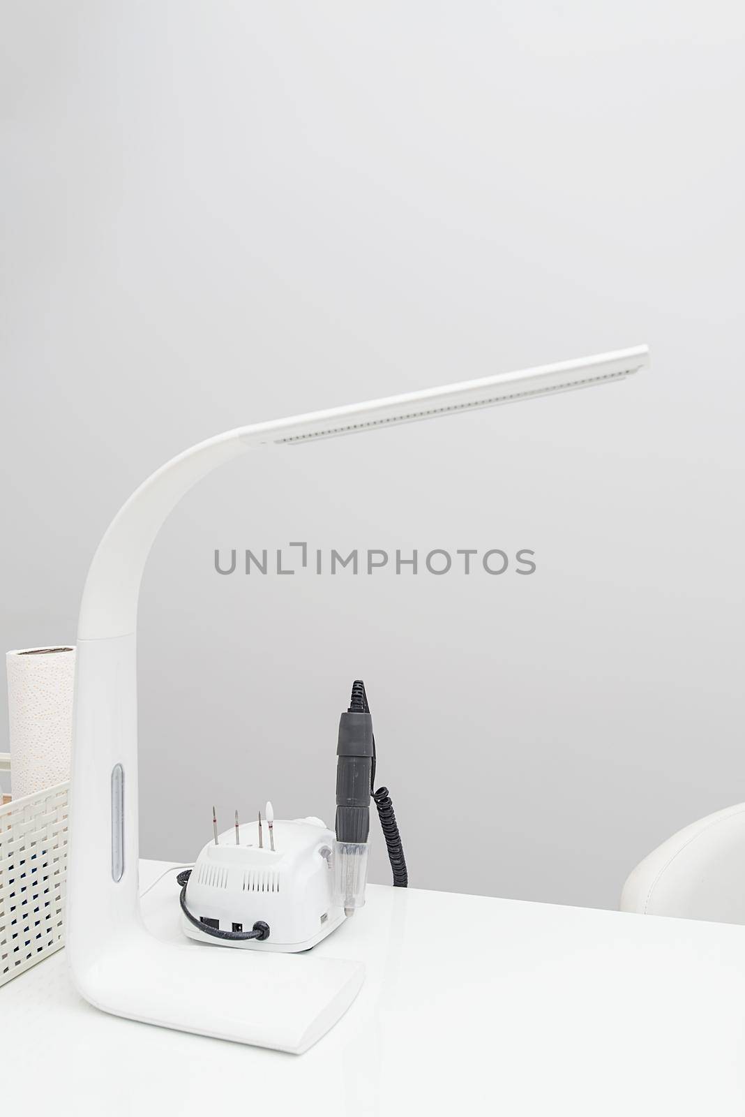 Manicure. White lamp on white table with nail tool by Ashtray25