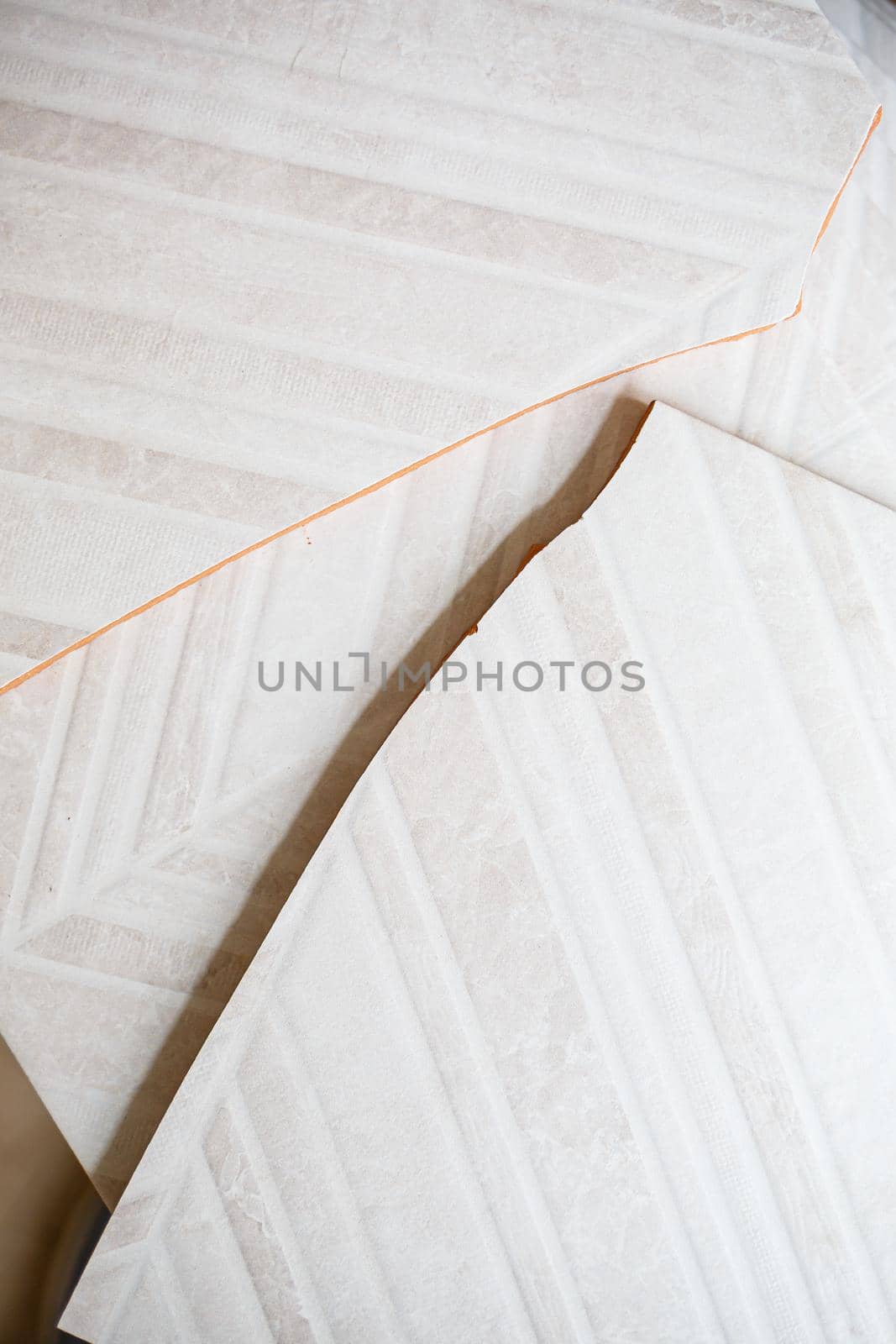 Pile of ceramic tiles in the bathroom, indoor walls. Conceptual repair in apartments, tile laying, repair inside. A pile of broken ceramic tiles remains after repairing the bathroom