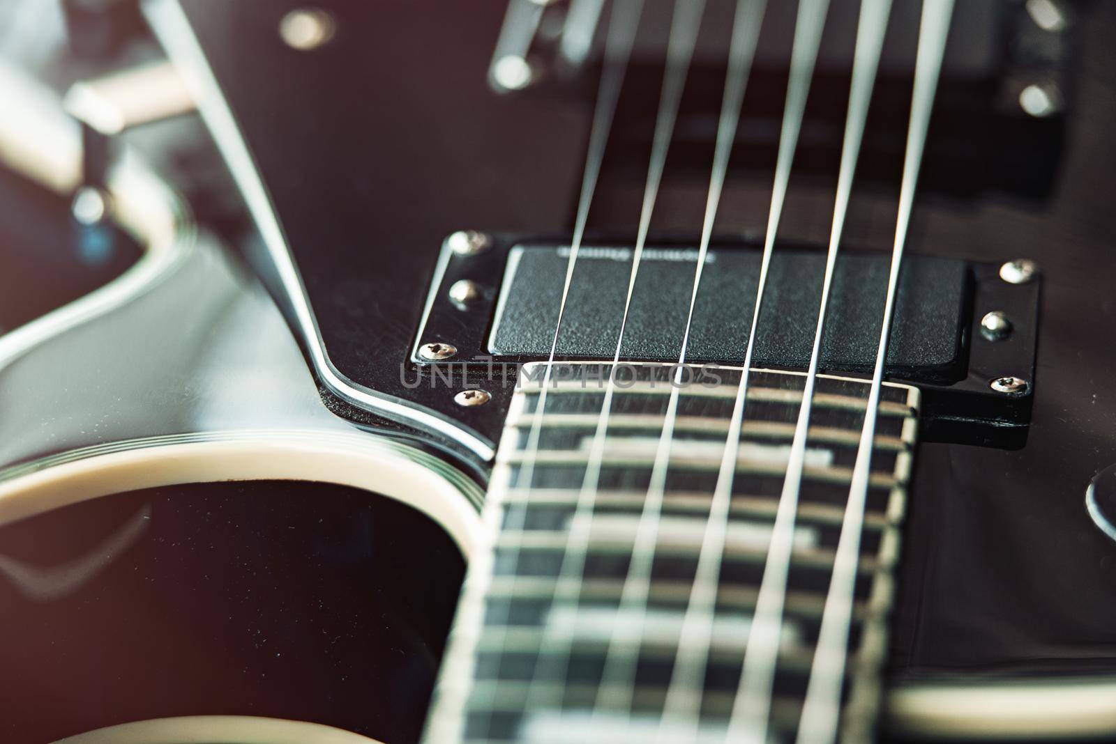 Detail of six-string electric guitar closeup, selective focus. vintage style.