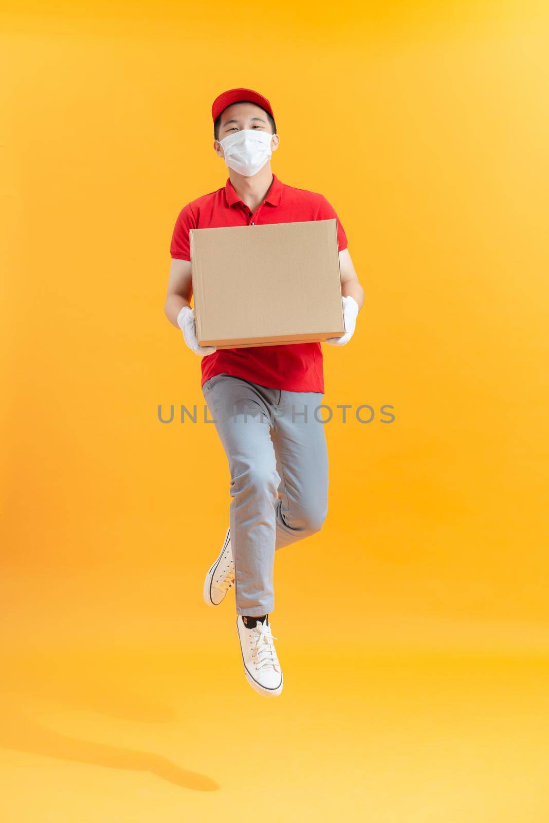 Male employee in cap t-shirt print working as courier dealer hold empty cardboard box by makidotvn