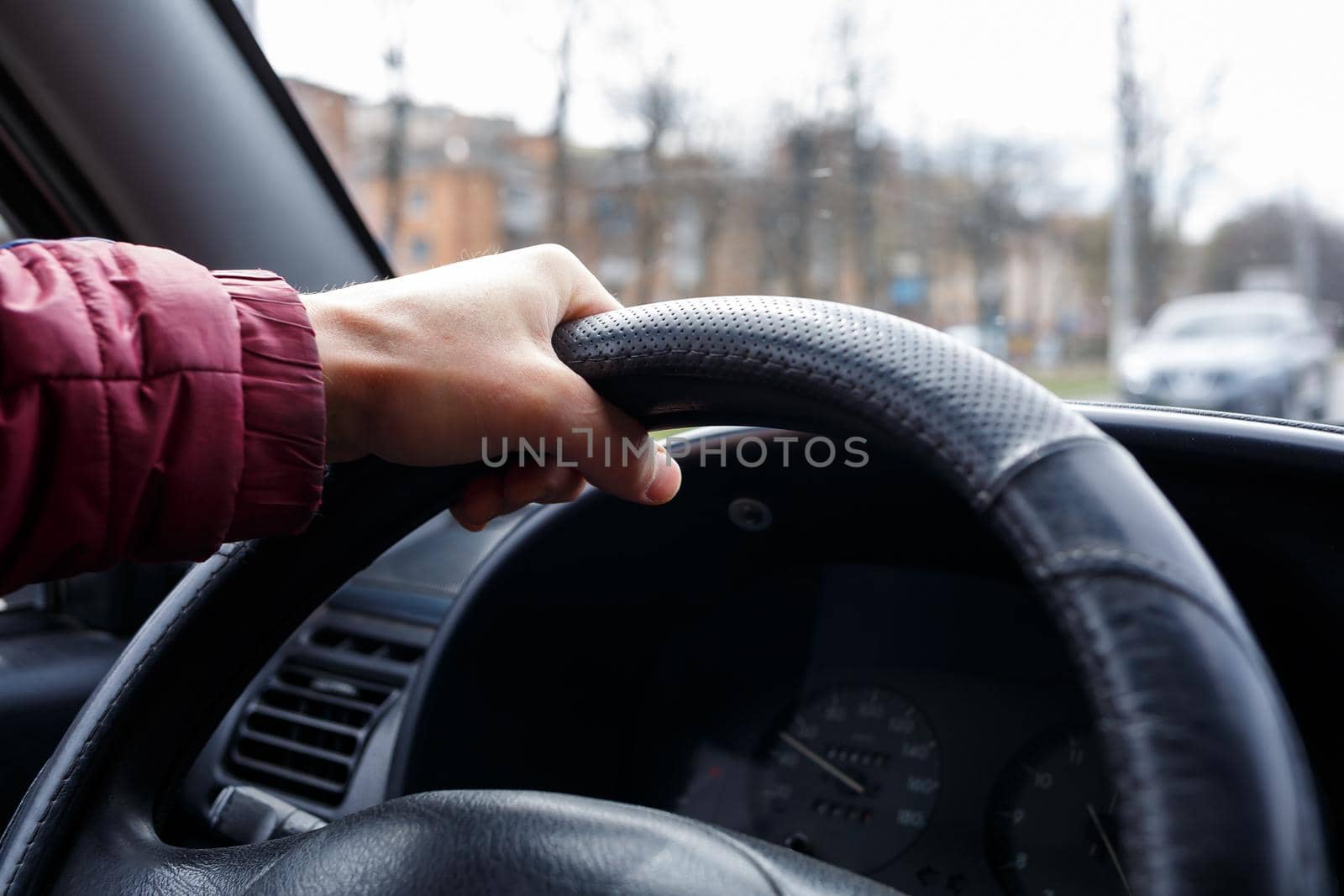 Male hand hold steering wheel in black leather, Man driving, transport concept,