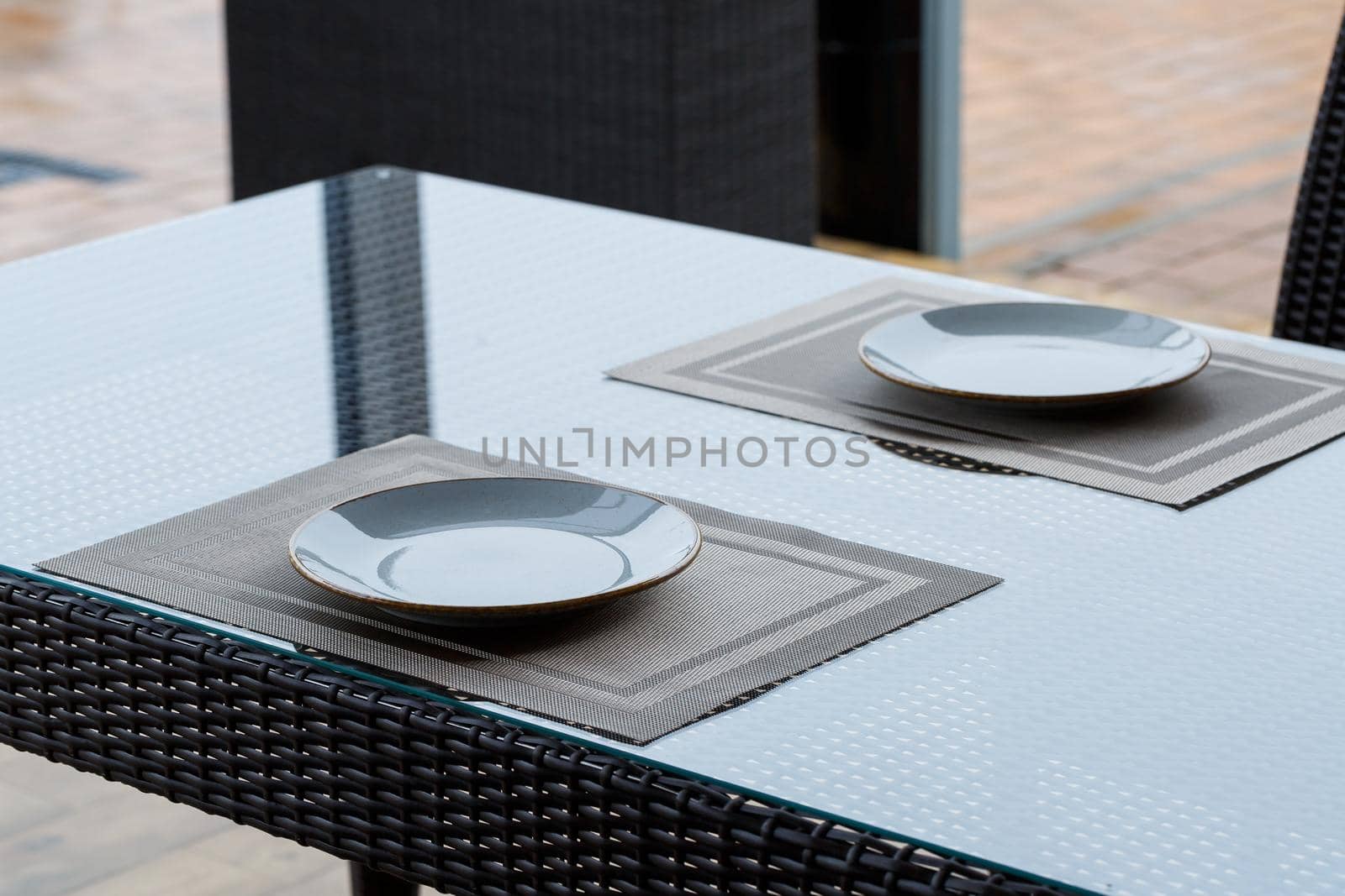Served table in a restaurant for two. Blue plates for food, two glasses. Romantic evening concept