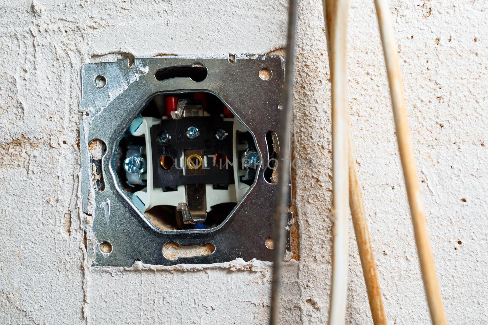 Sockets when mounted without a cover. During repair. open the wires. European nest without cover isolated on a white background. Professional installation of electrical outlets