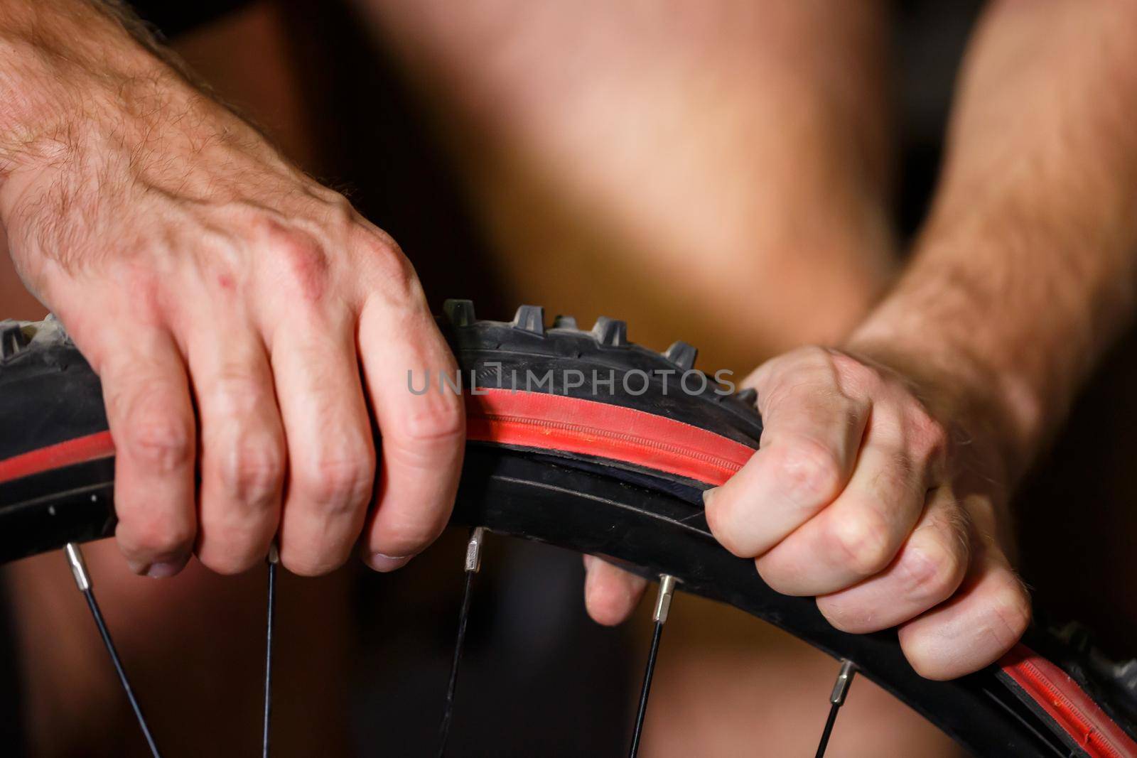 A man changes the camera on a bicycle wheel. Spike Bike Chamber