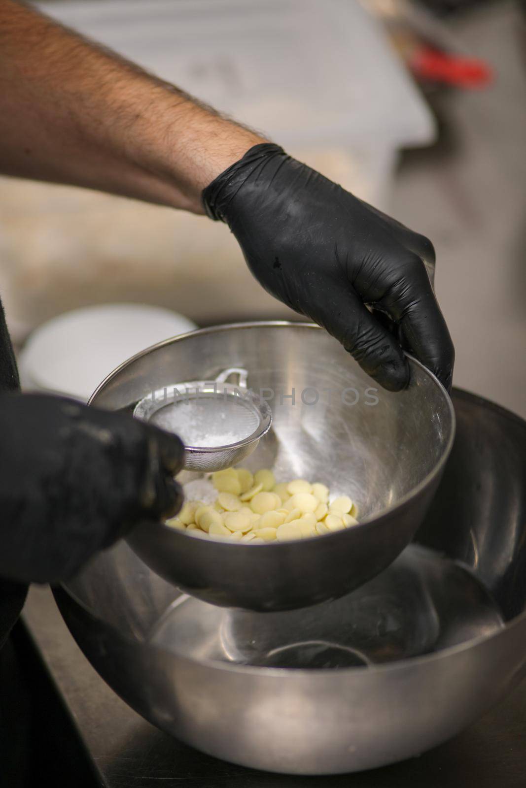 chef making for icing a lilac drip cake in the professional kitchen lab