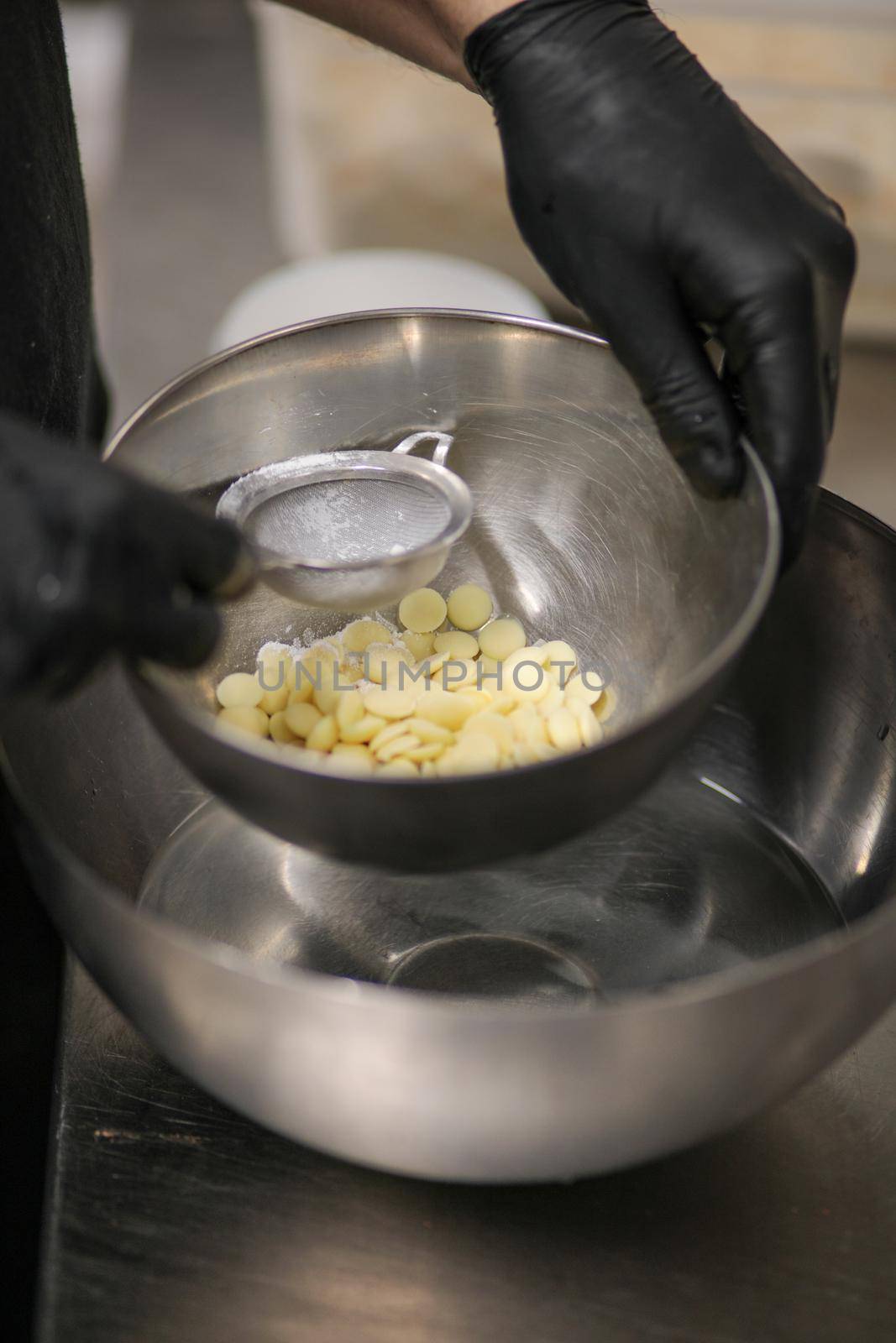 chef making for icing a lilac drip cake in the professional kitchen lab