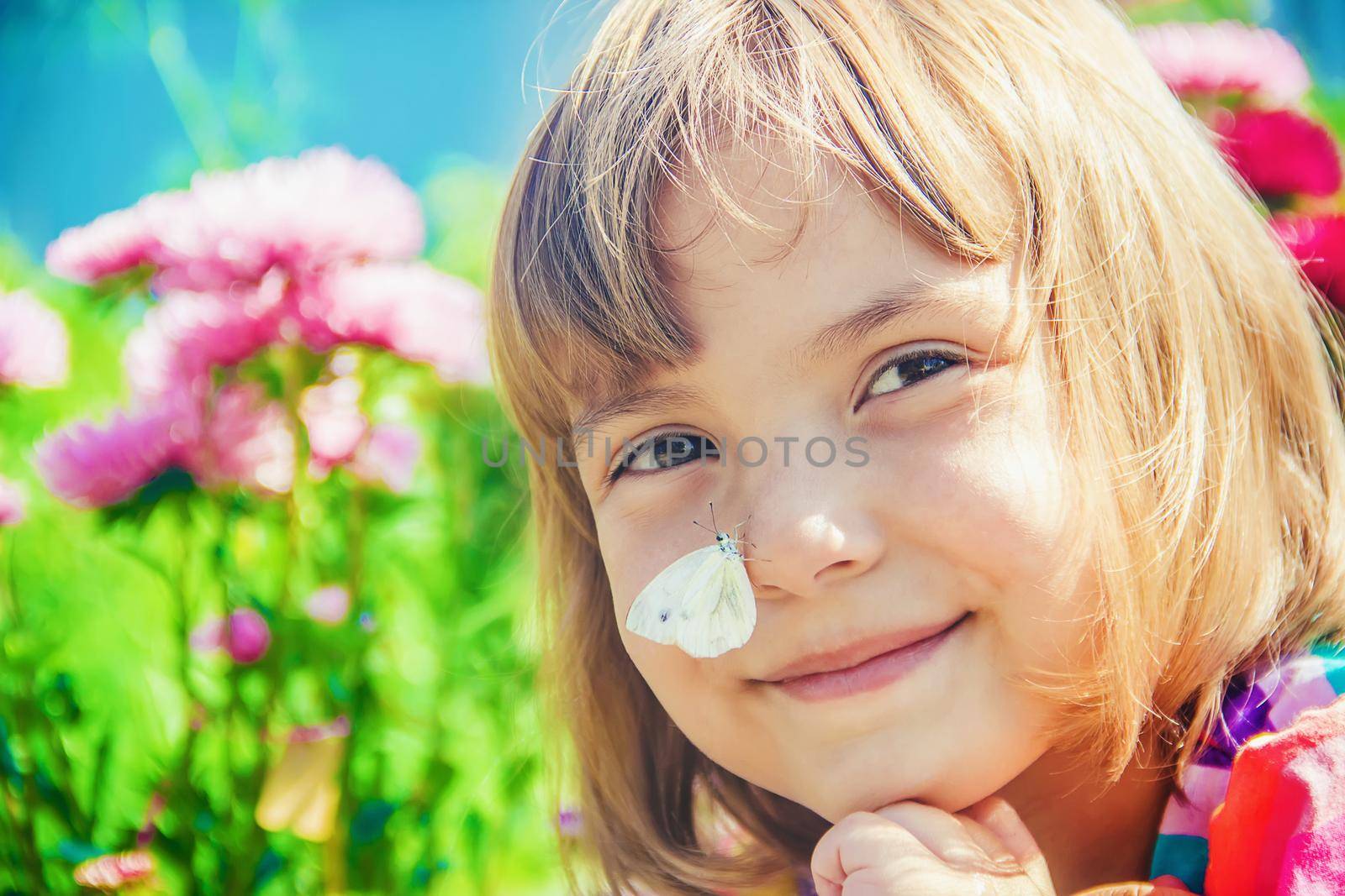 Child with a butterfly. Selective focus. nature. by yanadjana