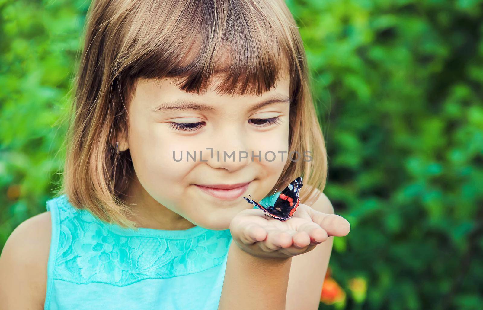 Child with a butterfly. Selective focus. nature. by yanadjana