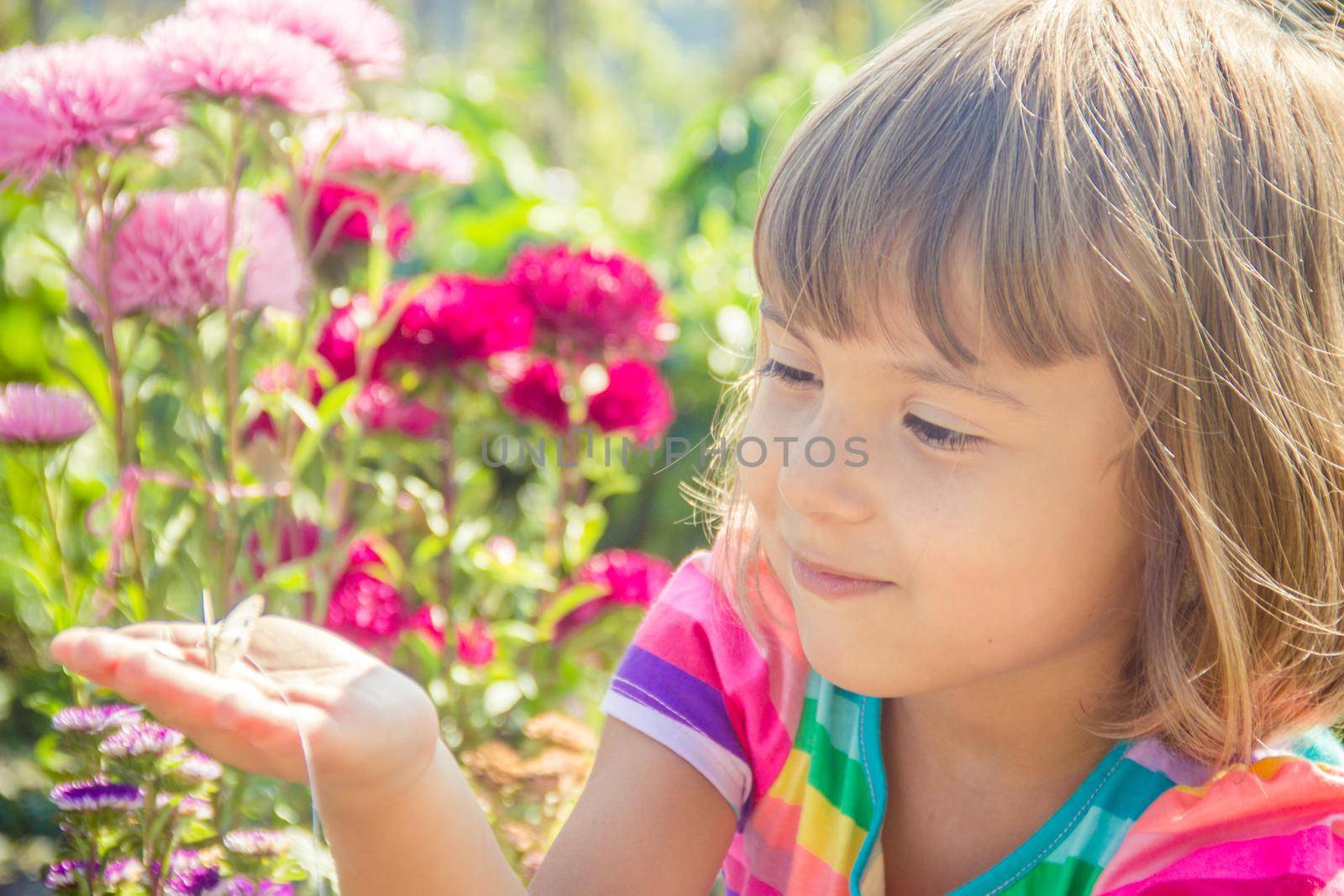 Child with a butterfly. Selective focus. nature. by yanadjana