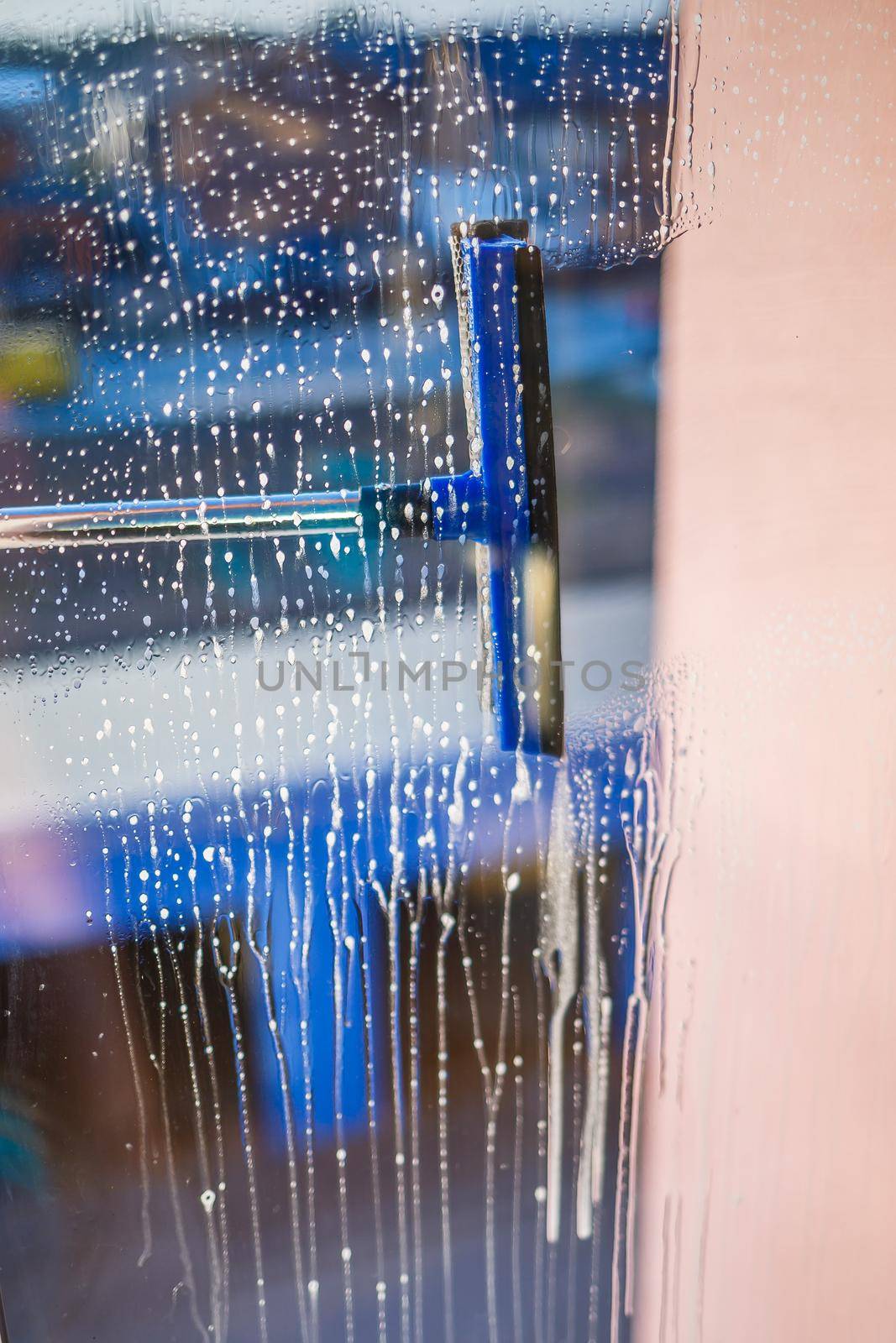 Window cleaning brush. Large window in a multi-storey building, cleaning service. Window cleaning in high-rise buildings, houses with a brush. Dust removal and glass washing.