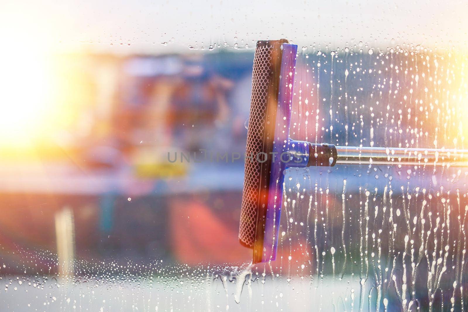 Window cleaning brush. Large window in a multi-storey building, cleaning service. Window cleaning in high-rise buildings, houses with a brush. Dust removal and glass washing.