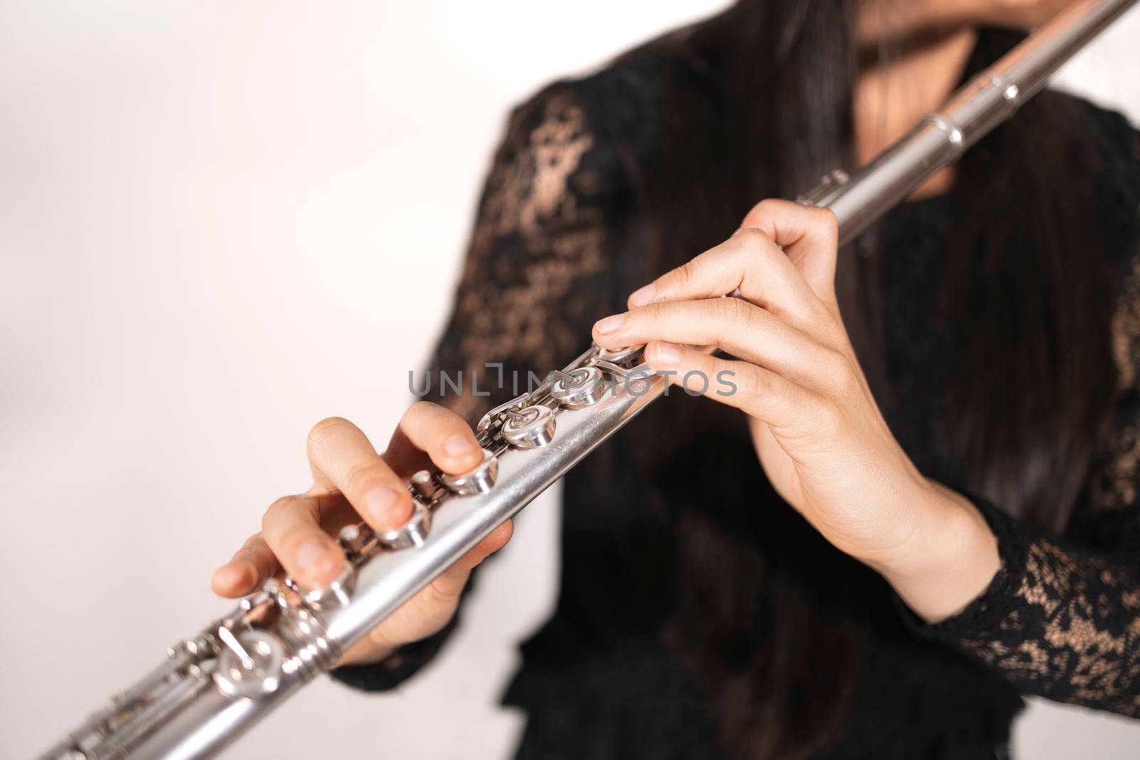 Close up of the hands of a female flutist while playing by stockrojoverdeyazul
