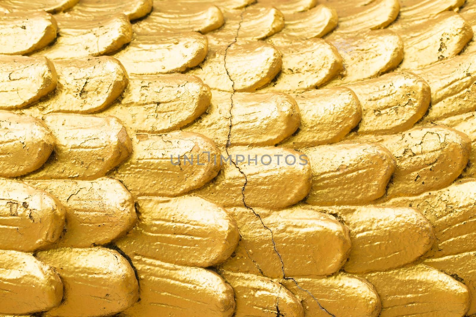 Golden scales with cracks close up surface.