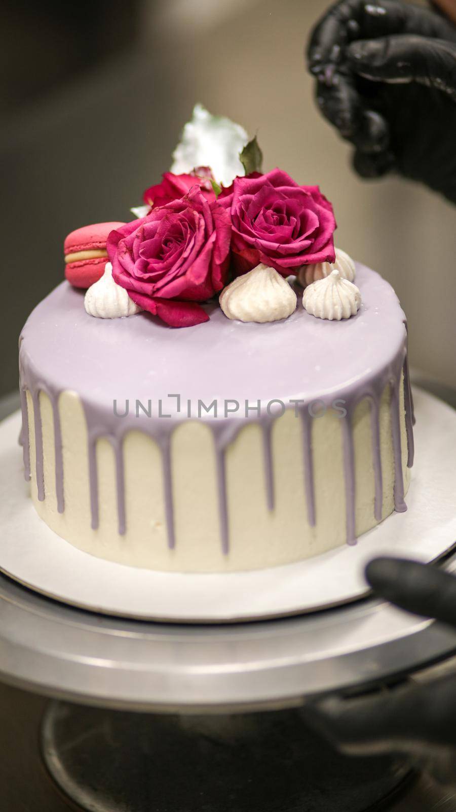 chef usign macaron , flowers and text sign for a celebration cake