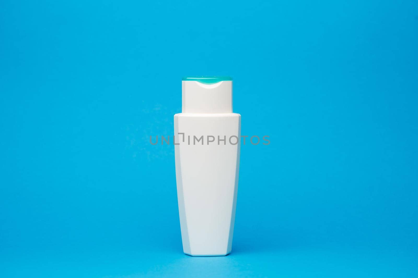 white bottle with cream, hair shampoo, shower gel, isolated blue background, human body beauty