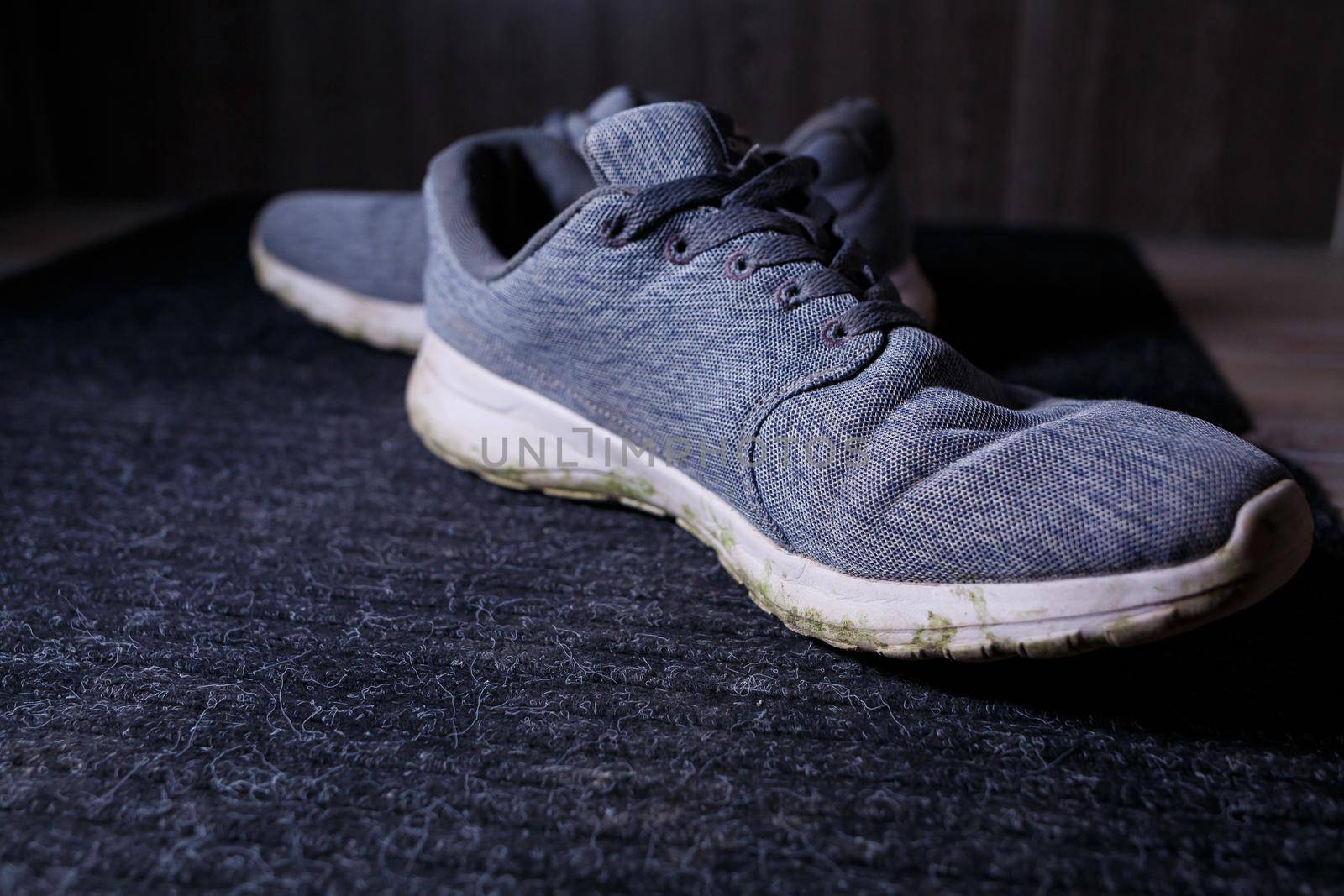 Gray men's sneakers with a dirty sole from the earth and grass, shoes for jogging and sports