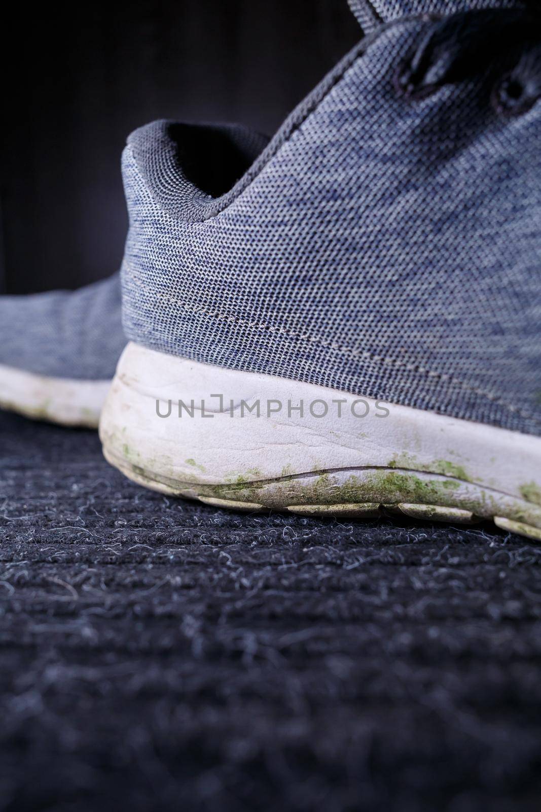 Gray men's sneakers with a dirty sole from the earth and grass, shoes for jogging and sports