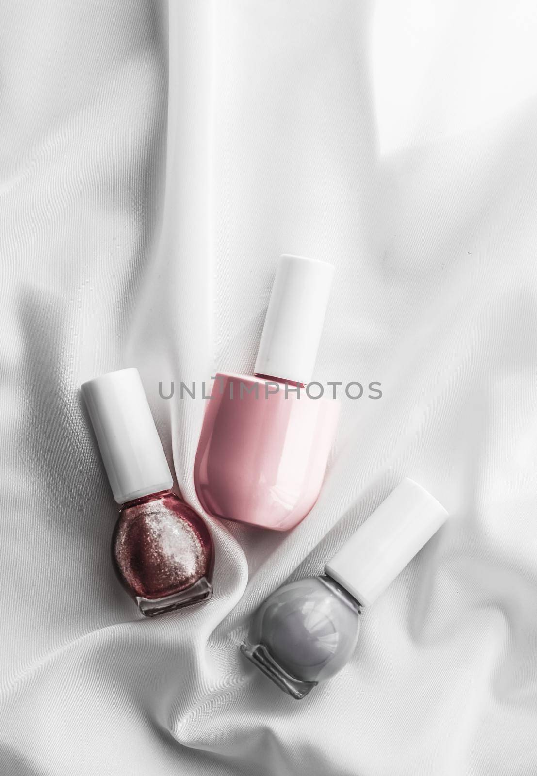 Cosmetic branding, salon and glamour concept - Nail polish bottles on silk background, french manicure products and nailpolish make-up cosmetics for luxury beauty brand and holiday flatlay art design