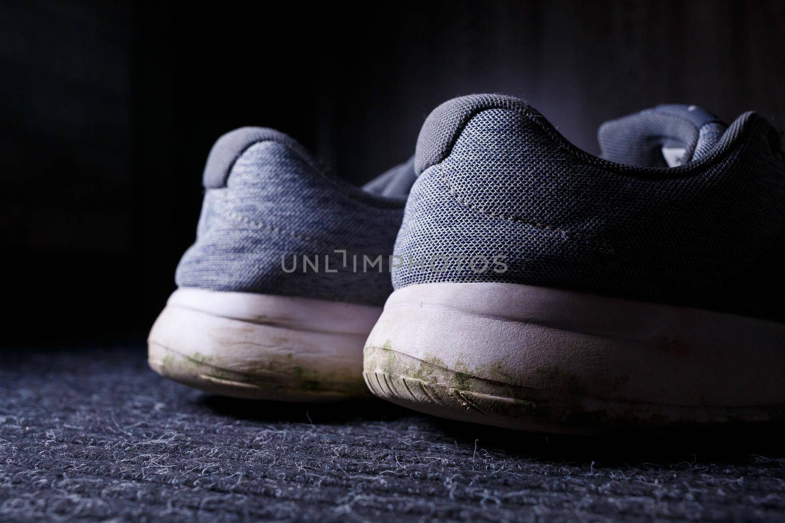 Gray men's sneakers with a dirty sole from the earth and grass, shoes for jogging and sports
