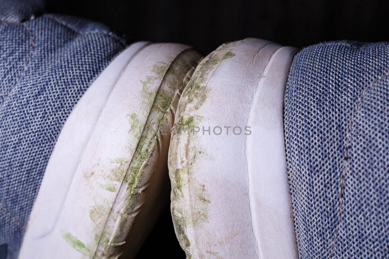 Gray men's sneakers with a dirty sole from the earth and grass, shoes for jogging and sports