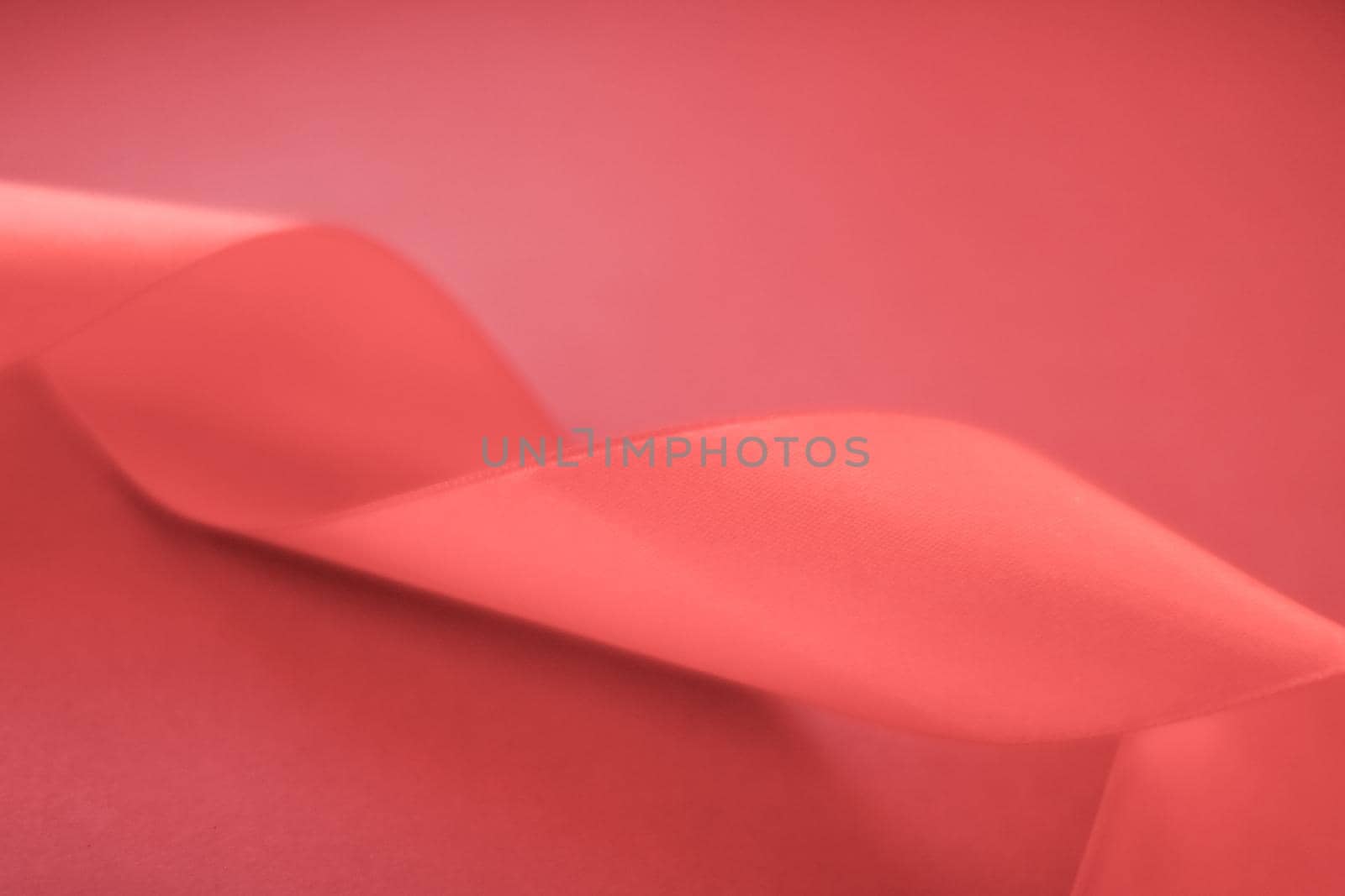 Branding, holidays and luxe brands concept - Abstract curly silk ribbon on coral background, exclusive luxury brand design for holiday sale product promotion and glamour art invitation card backdrop